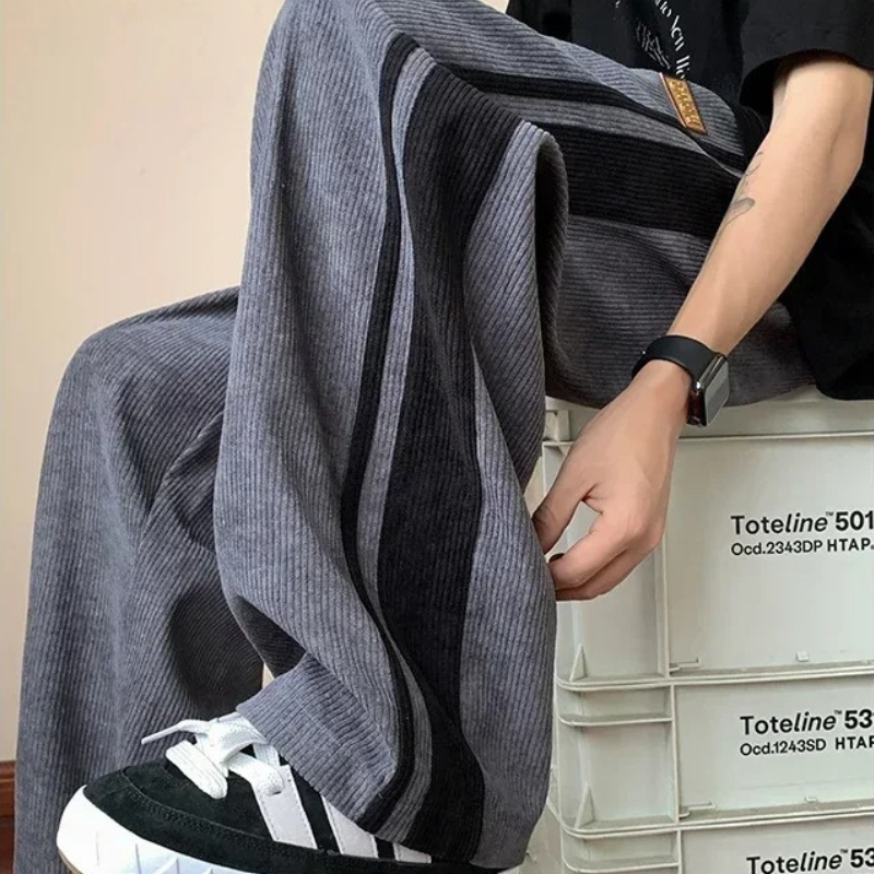 Modell i herre oversized joggebukser med elastisk midje og snøring, perfekt for hverdagsbruk og fritid.