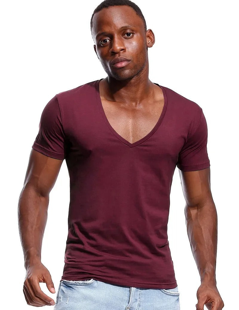 Mann i en stilfull, komfortabel slim fit t-skjorte med dyp V-hals. Perfekt hverdagsklær.