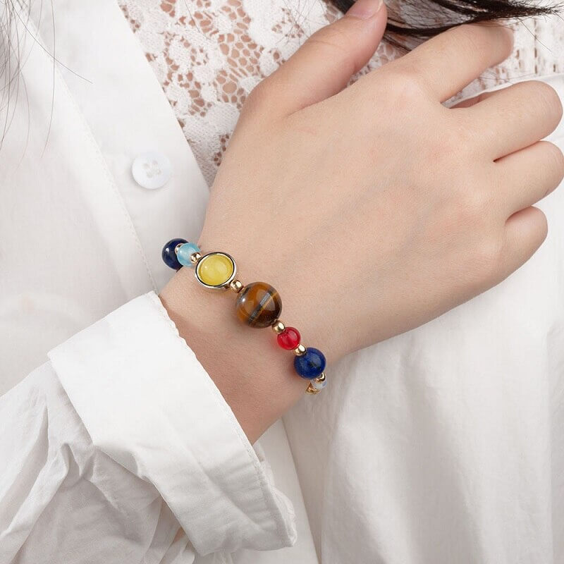 Elegant naturstein armbånd, inspirert av solsystemet. Justerbart krystall smykke for et unikt astronomisk preg.