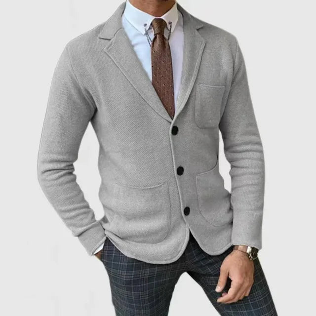 Mann kledd i komfortabel marineblå strikkblazer og jeans. Ideell for uformelle anledninger, menns smart casual mote.