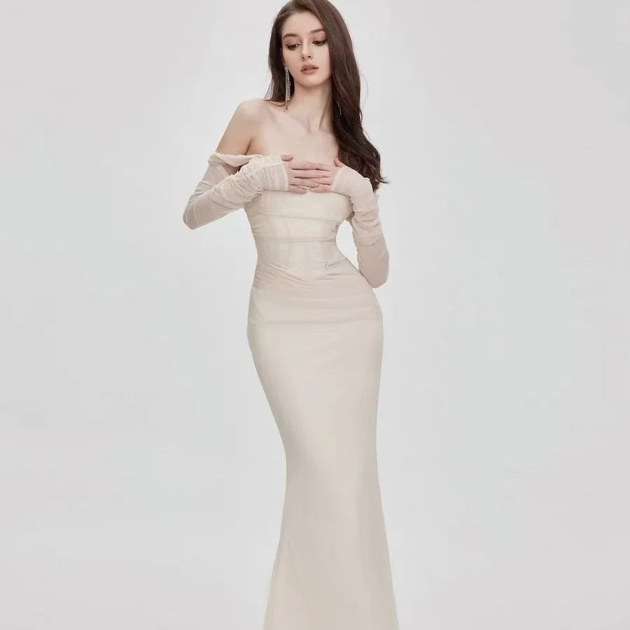 Detaljert off-shoulder havfruekjole med meshdetaljer. Kvinnekjole for formell fest, figurnær og elegant.