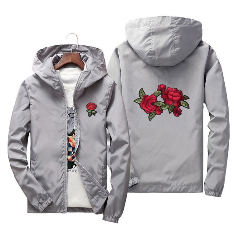 Kvinne i lett, vanntett damevindjakke med elegant roseprint. Perfekt yttertøy for sport.