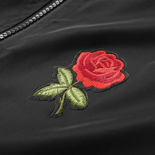 Aktiv kvinne iført lett, vanntett vindjakke med roseprint i naturlige omgivelser.
