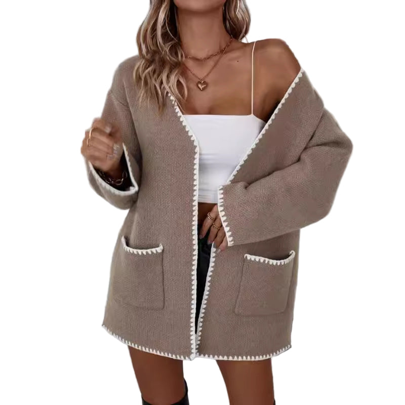 Kvinne oversized strikket cardigan med åpen front og praktiske lommer, perfekt for høst- og vintermåneder.