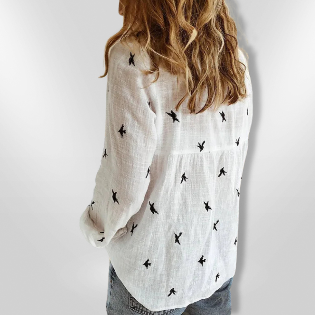 Bluse med detaljert fuglemotiv, langermet design og knappestolpe. En elegant vår- og sommerfavoritt.