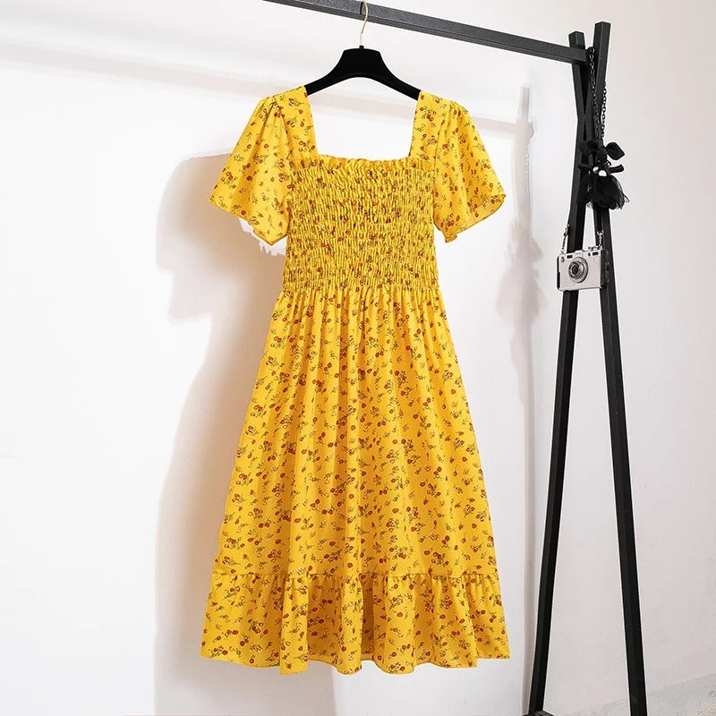 Livlig blomstret mønster på elegant midikjole for kvinner. En frisk sommerkjole som passer til enhver anledning.