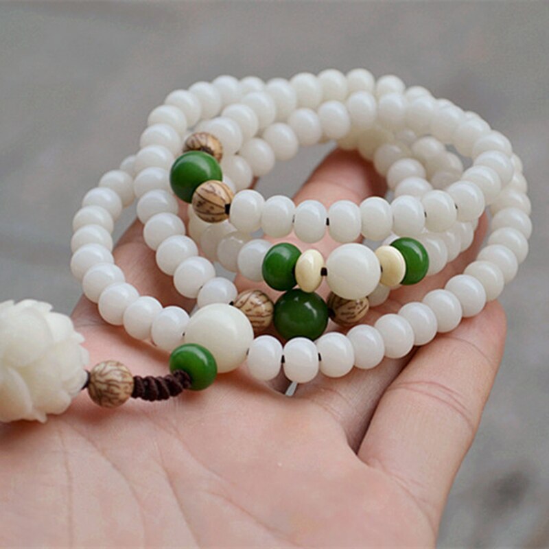 Nærbilde av Bodhi Lotus perlearmbånd. Detalj av naturlige perler, intrikat lotus-design, ideelt for meditasjon.