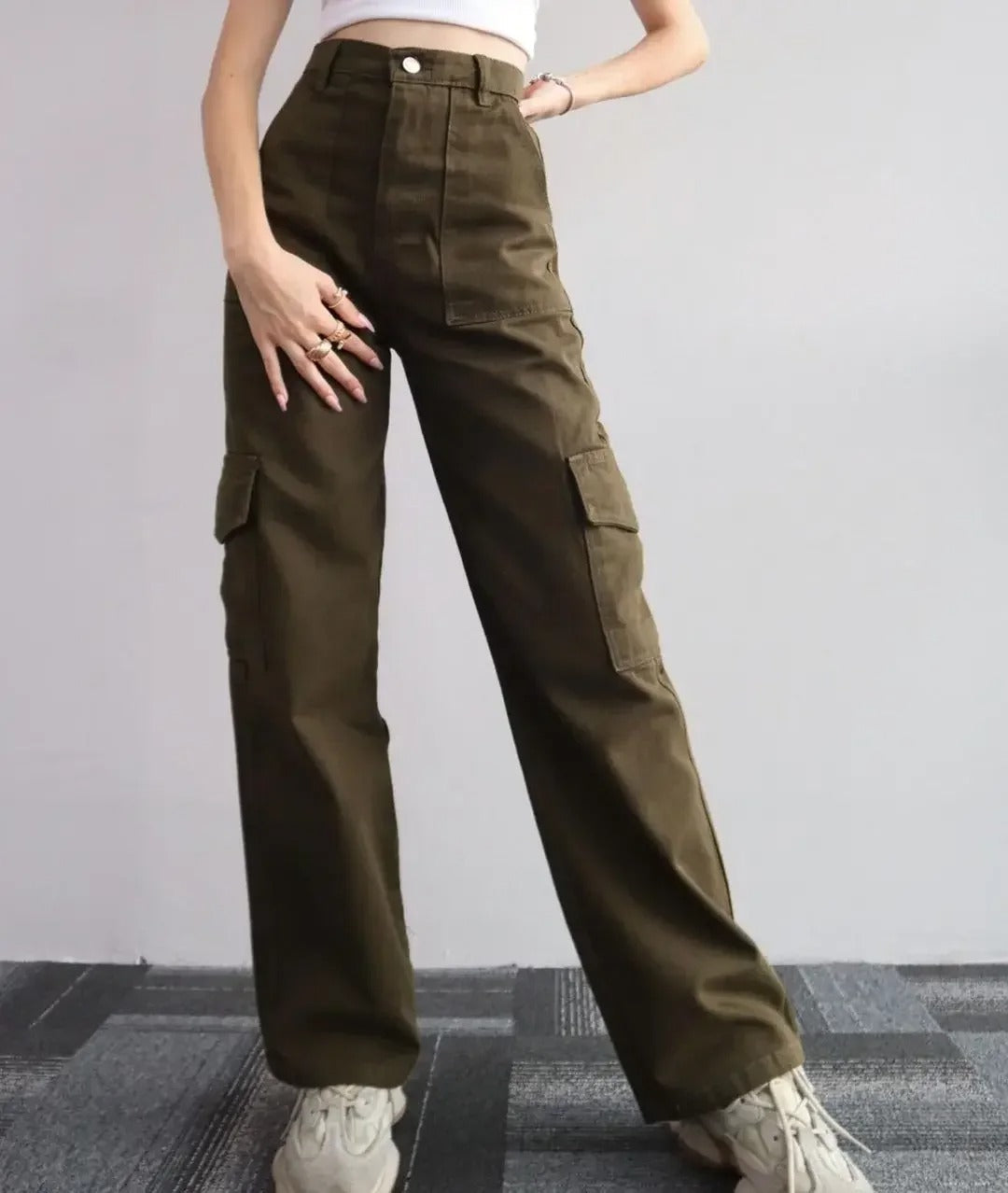 Kvinne i dynamisk positur med trendy cargobukser, mange lommer, perfekt for aktiv fritid og streetwear.