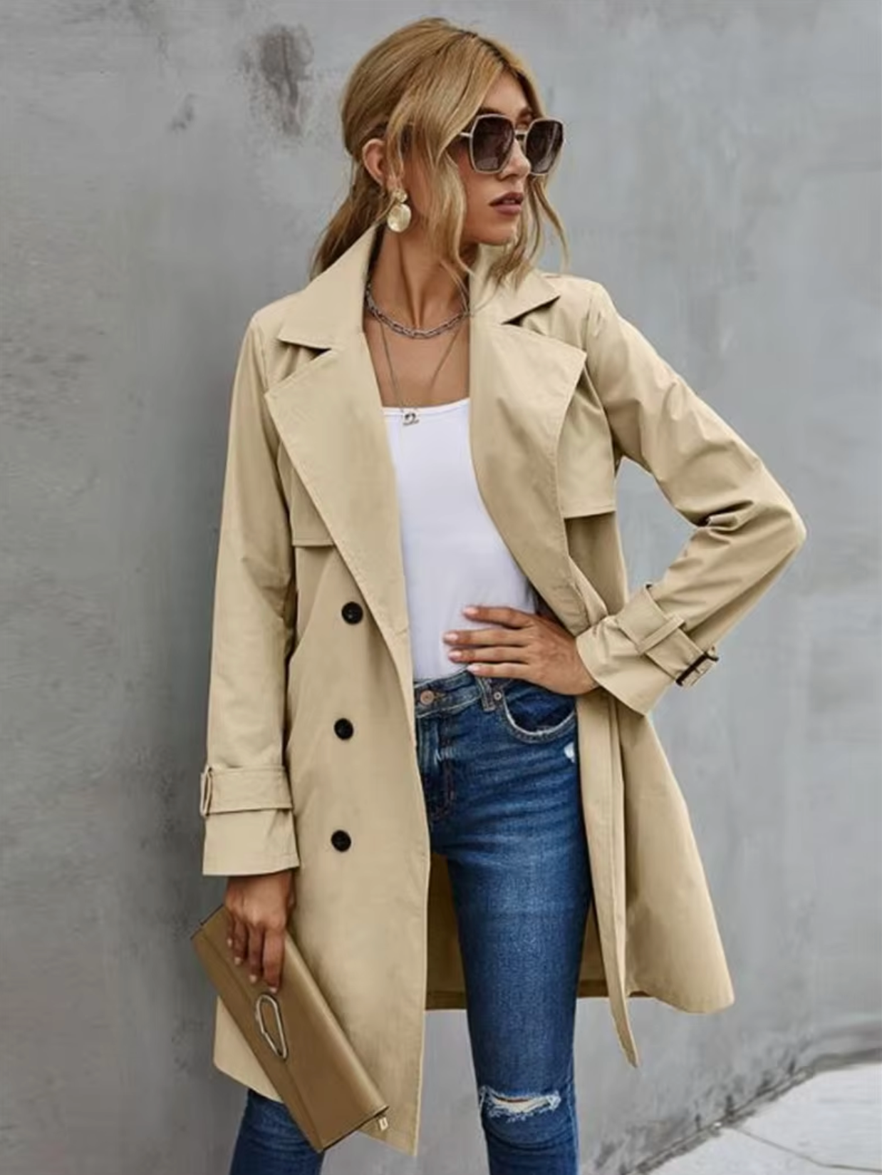 Nærbilde av tidløs kvinners trenchcoat. Viser dobbelspent lukking, belte og krage. Ideell vår-/høstjakke.