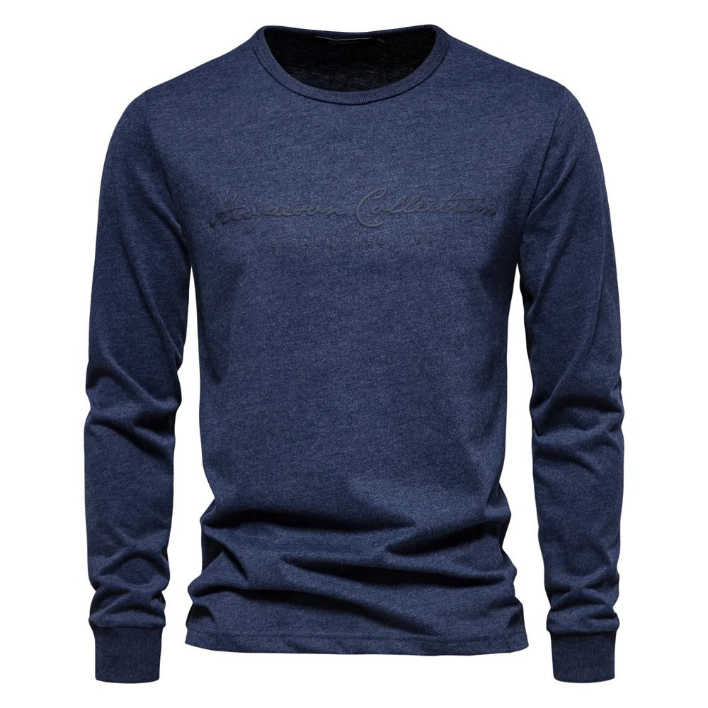 Herre langermet t-skjorte med moderne bokstavtrykk, vist på modell. Komfortabel passform for en trendy hverdagslook.
