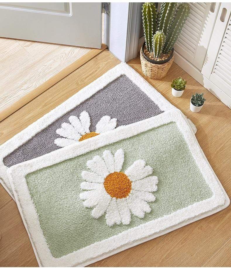 Grå baderomsmatte med grønne tusenfryd. Blomstermatte som gir badet et friskt, innbydende preg.