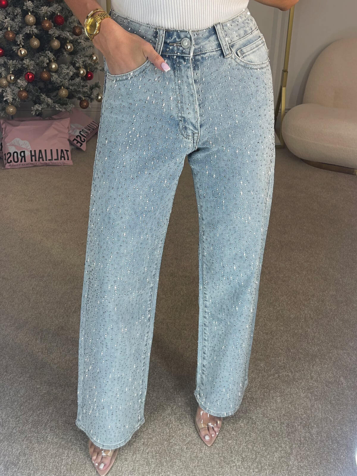 Full lengde bilde av stilige damejeans med høy midje, mørkeblå farge og glitrende aksenter.