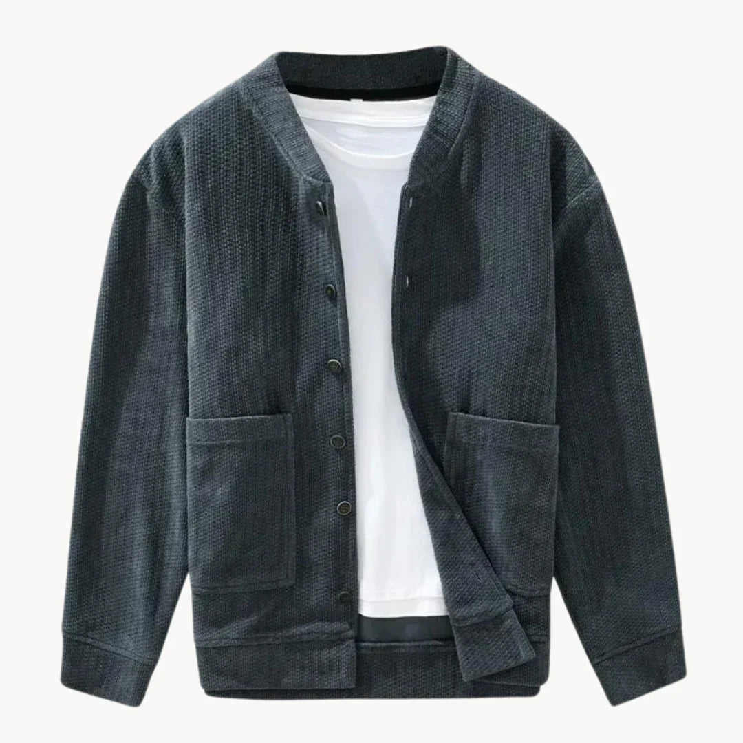 Nærbilde av teksturert herre cardigan med mønstret strikk. Moderne stil for lag-på-lag høstmote.