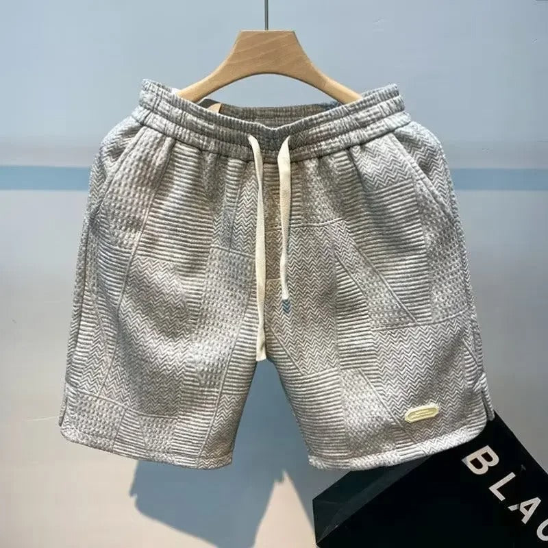 Nærbilde av menns sportsshorts med elastisk linning og praktiske lommer for funksjonalitet.