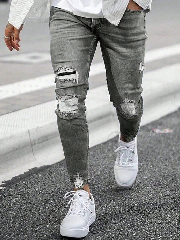 Trendy menns rippede skinny denim jeans, kombinerer komfort med dristig herreklær mote.