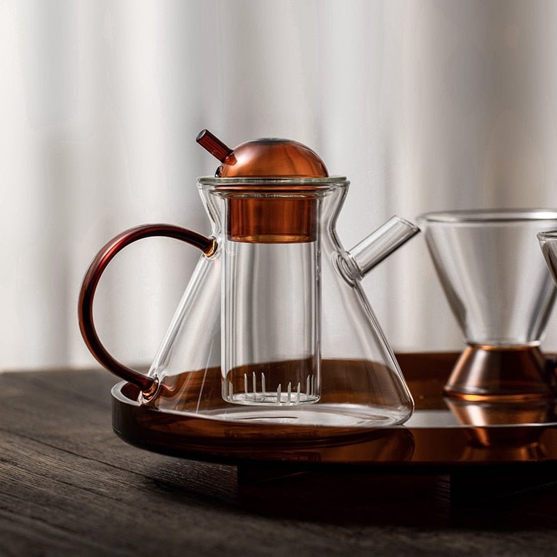 Varm te helles fra minimalistisk borosilikatglass tekanne til matchende kopp, et hyggelig øyeblikk.