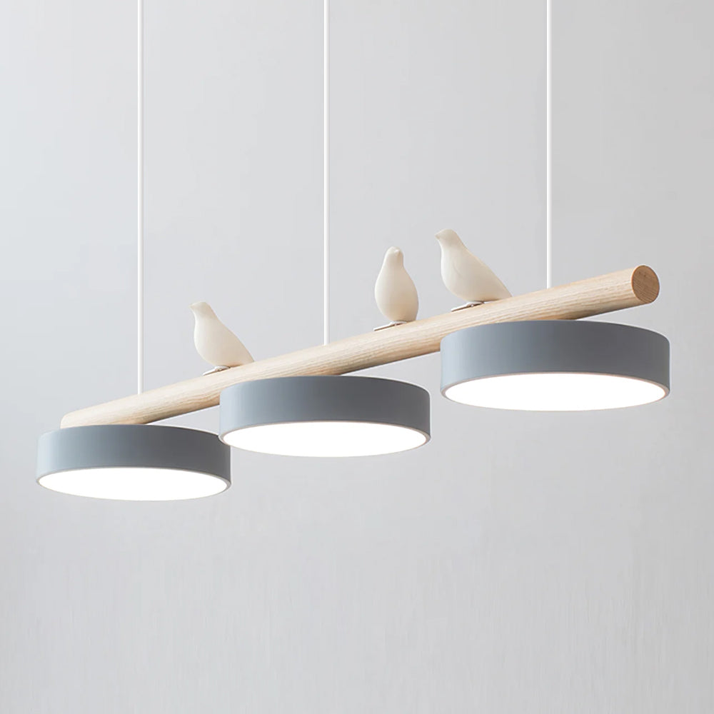 Elegant taklampe med gullfugler, skaper stemning over moderne spisebord.