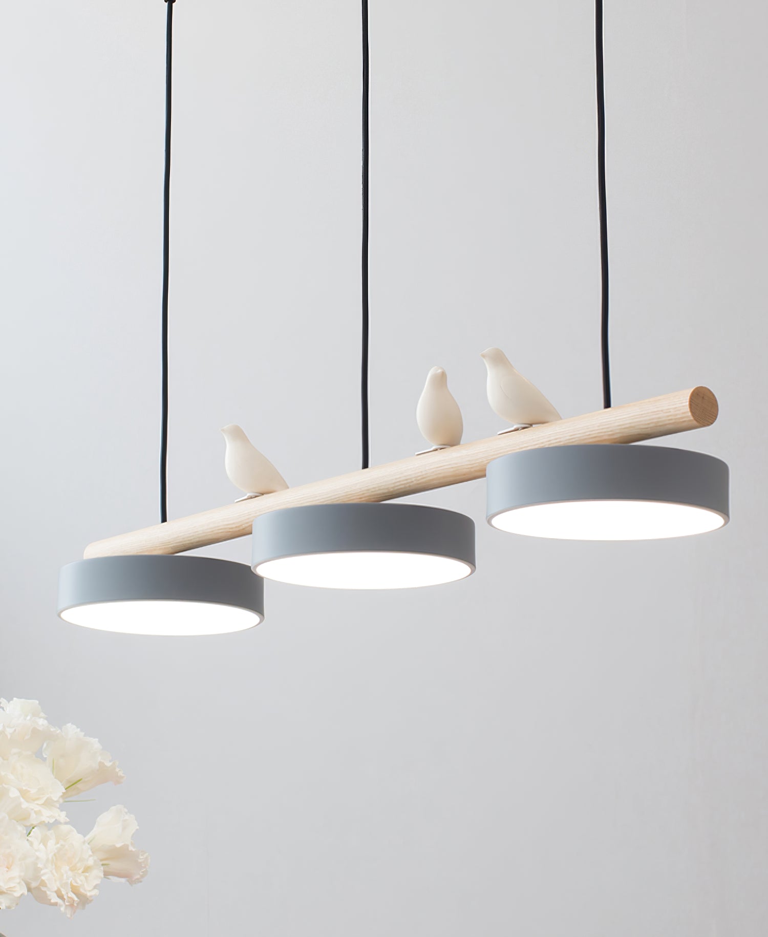 Stilren pendellampe med fugler, ideell for designer-inspirert spisebordsbelysning.