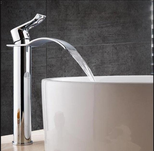Minimalistisk baderomskran med strømlinjeformet design og beroligende fosseeffekt for et spa-lignende bad.