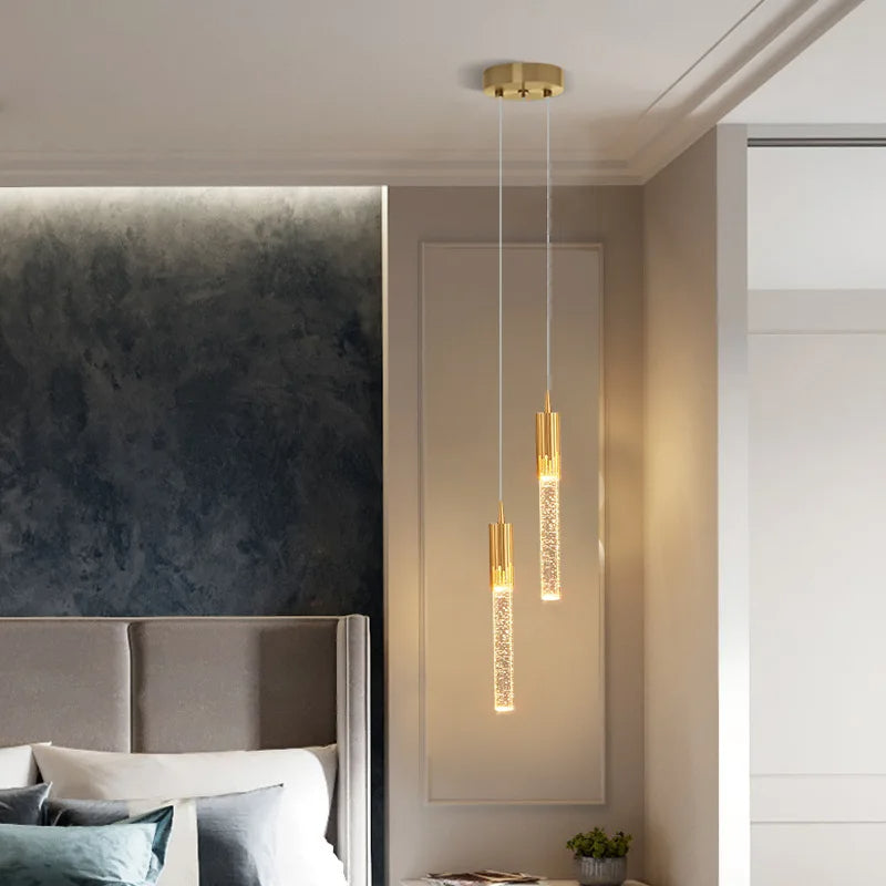 Designertaklampe i svart og gull, med sylindrisk form som et stilfullt blikkfang i stuen.