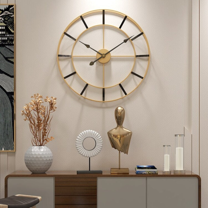 Stilren veggklokke med gull metallramme og sort urskive. Minimalistisk design for hjemmeinnredning.