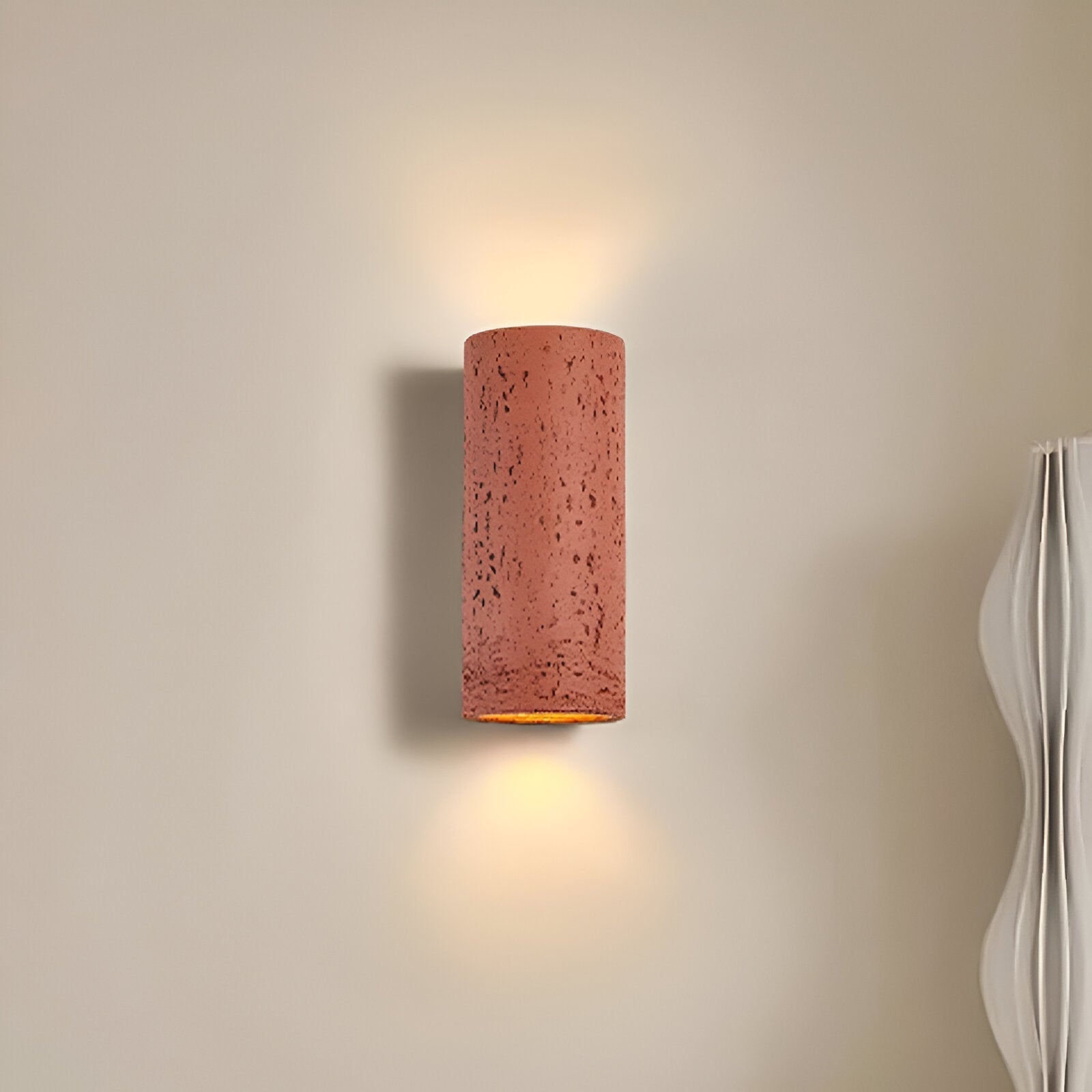 Elegant sylinder vegglampe i minimalistisk design. Kunstnerisk opp-og-ned belysning skaper unikt stemningslys.
