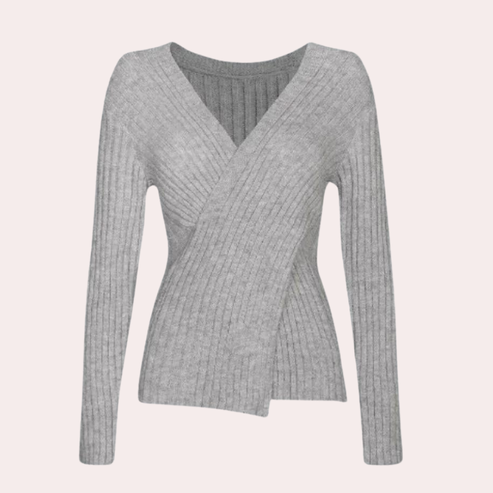 Kvinne iført trendy v-hals genser med kryssdetalj. En feminin og stilfull casual look.