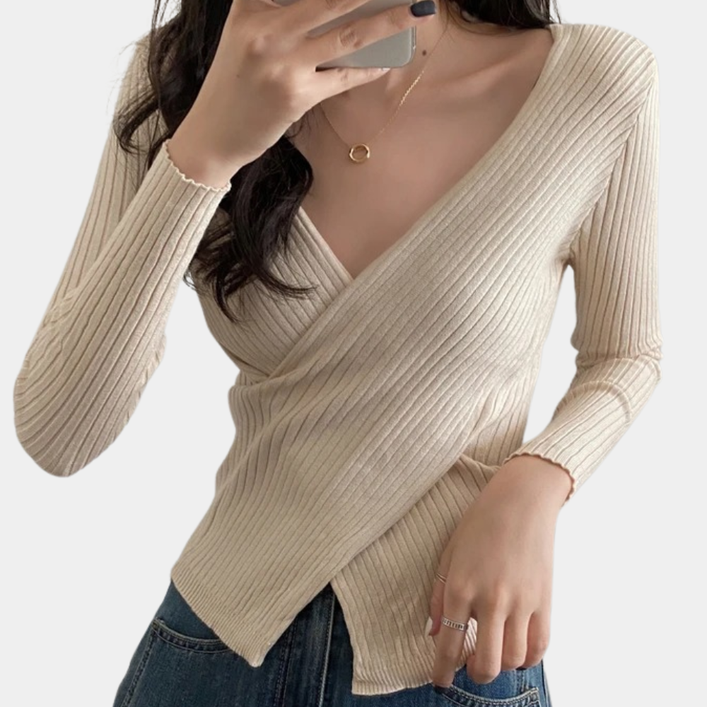 Nærbilde av kryssdetalj på elegant v-hals genser for dame. Trendy og stilfull strikk.