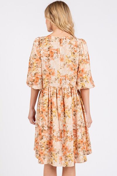 Lekker babydoll minikjole i oransje med fargerikt blomstertrykk. Løs og luftig passform for sommerdager og fest.