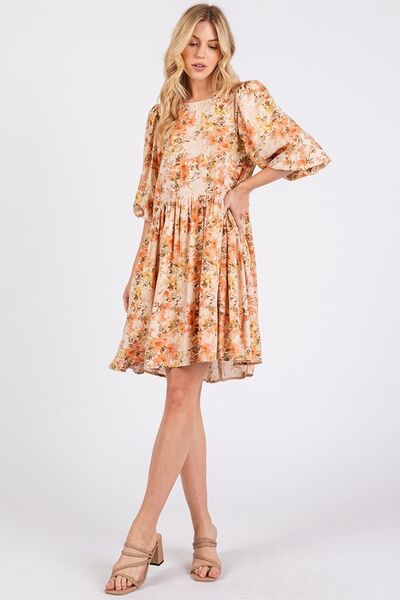 Dame minikjole med babydoll-snitt og friskt blomstermønster. Oransje sommerkjole ideell for casual look.