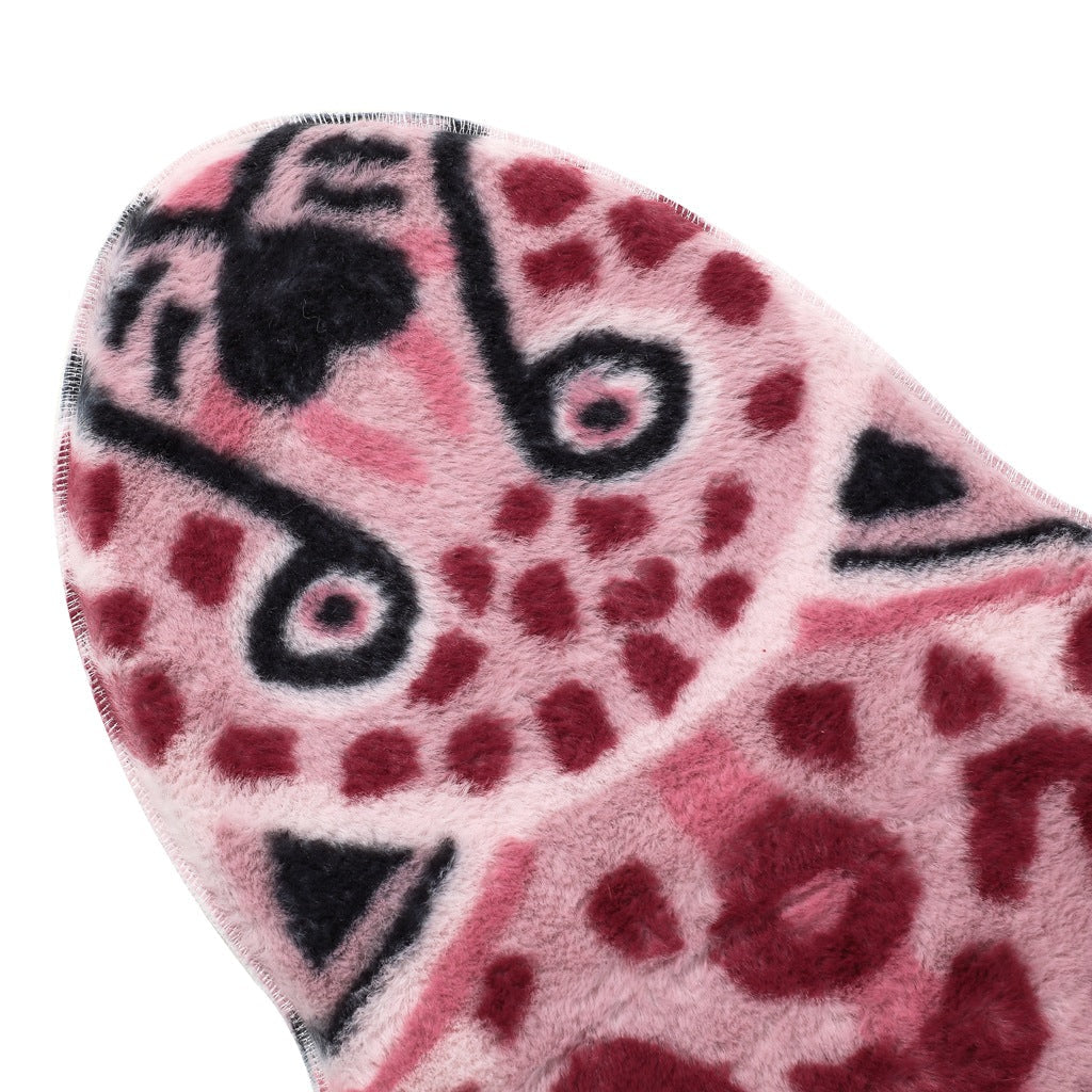 Stort rødt leopardteppe som sentralt element i en moderne stue, skaper et unikt interiør.
