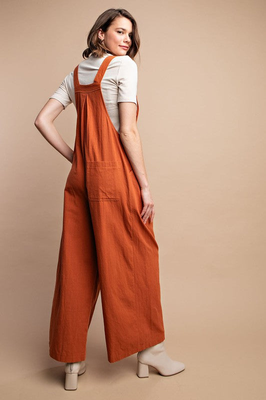 Stilren rustfarget dameoverall med synlige pintuck-sømmer og funksjonelle lommer for en komplett og komfortabel look.