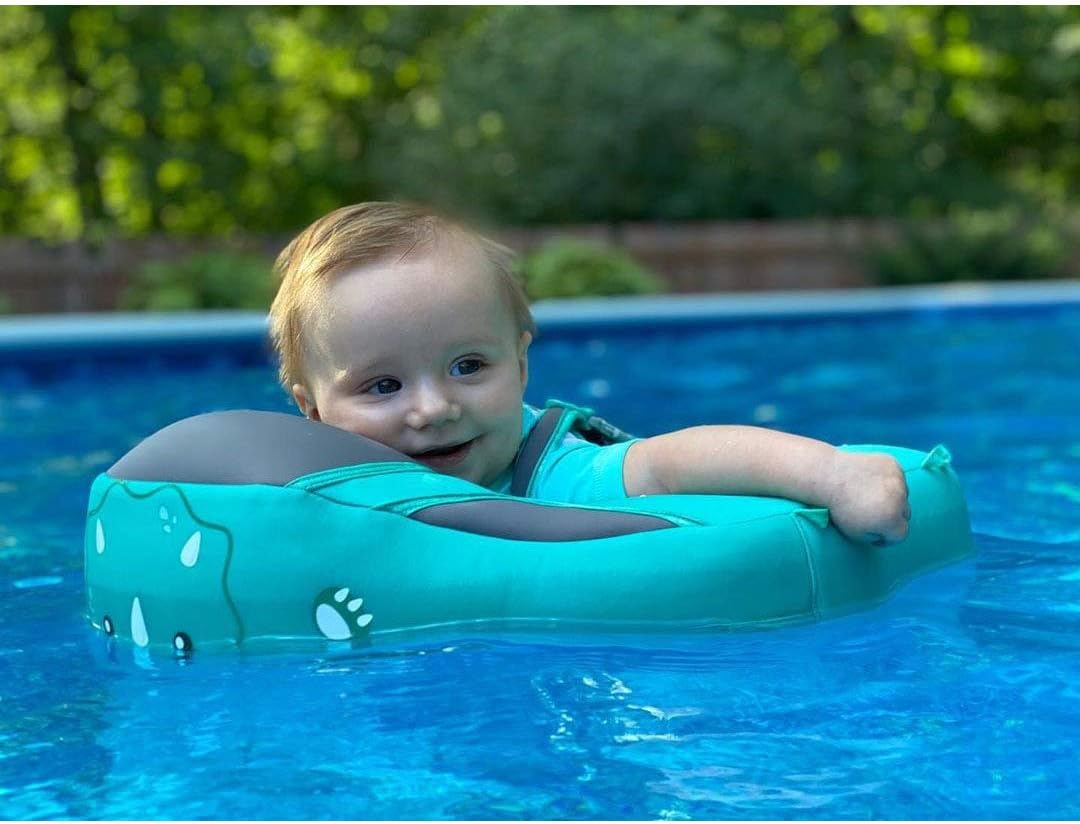 En baby lærer svømming med en smart og trygg svømmetrener, utvikler selvtillit i vannet.