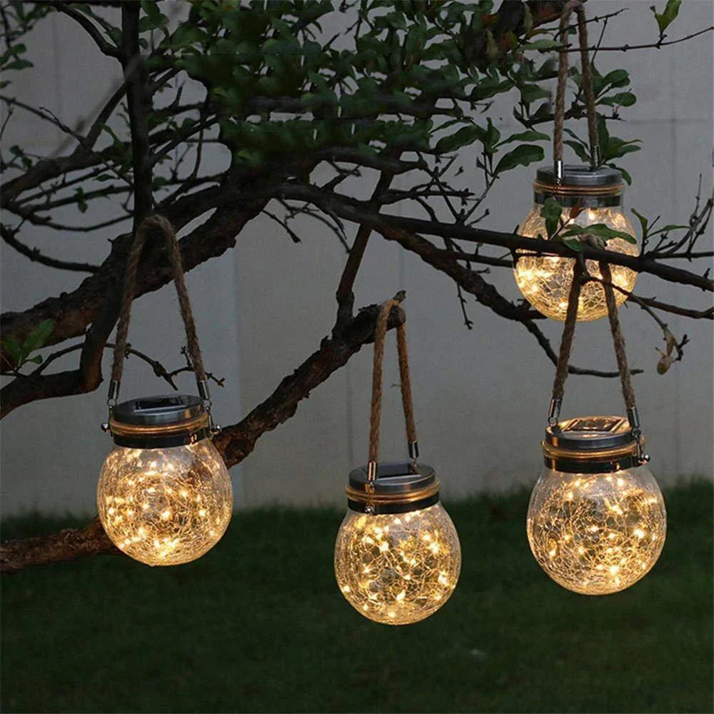 Nærbilde av solcellelampe som viser detaljer i sprukket glass og robust hampsnor, klar til å lyse.