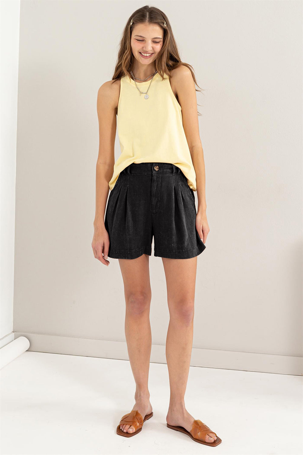 Svarte dame shorts med flatterende høy midje og detaljerte folder, perfekt for sommerdager.