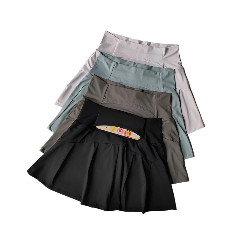 Modell iført sporty skjørtshorts med høy midje. Ideell for trening, tennis, golf. Aktivklær for kvinner.