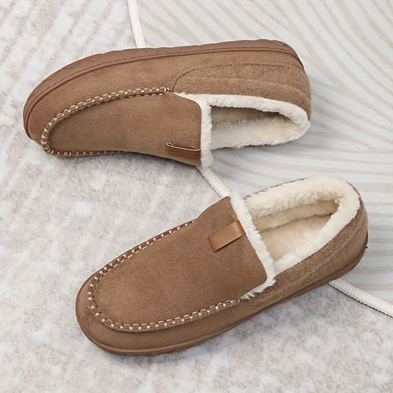 Herre vinter loafers i bruk ved peisen, symboliserer varme, komfort og koselig hjemmebruk.