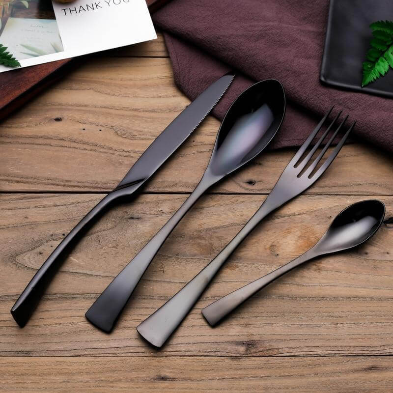 Nærbilde av en elegant svart kniv i rustfritt stål fra det 4-delte bestikksettet.