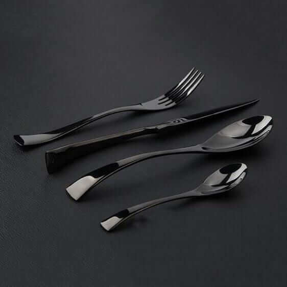 Komplett 4-dels bestikksett: svart kniv, gaffel, skje i elegant rustfritt stål for servering.