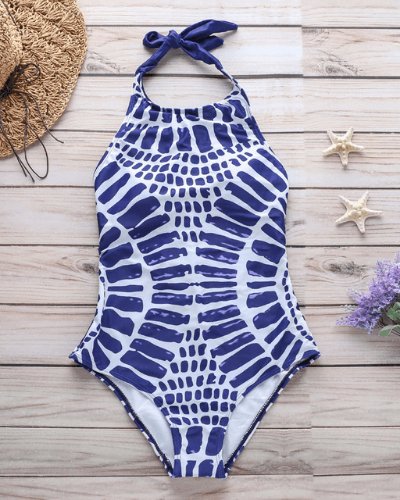 Kvinne i elegant svart og blå badedrakt med kryssrygg, klar for sommer og strand.