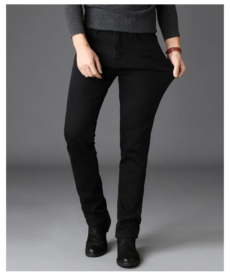 Nærbilde av svarte stretch-bikerjeans for menn, som viser stoffets fleksibilitet og slimfit passform.