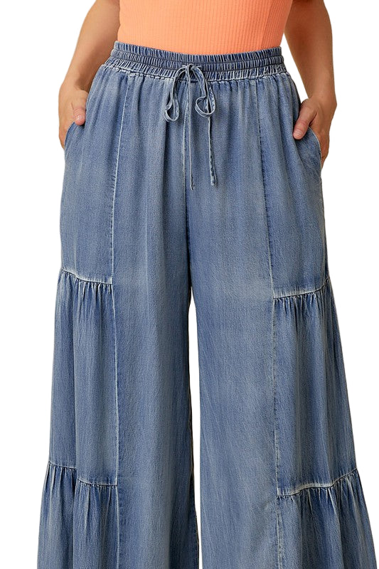 Trendy damebukser med brede volanger og vasket denimlook. Komfortable vide bukser for sommer og hverdag.