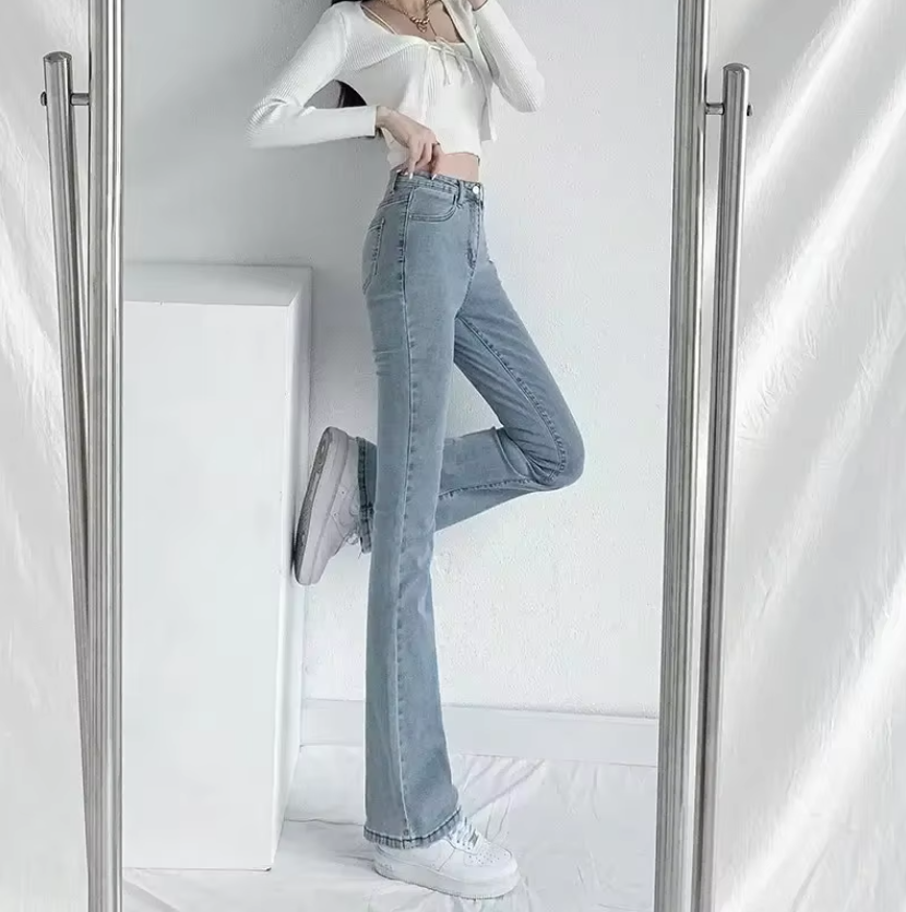 Detaljer av damebukser: Høy midje, utsvingte ben og klassisk blå denim. Trendy og allsidig stil.