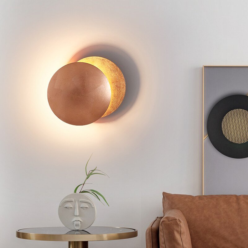 Elegant interiørdetalj; vegglampe i gull/roségull med mystisk lysspill. Moderne LED-lampe for hjemmeinnredning.