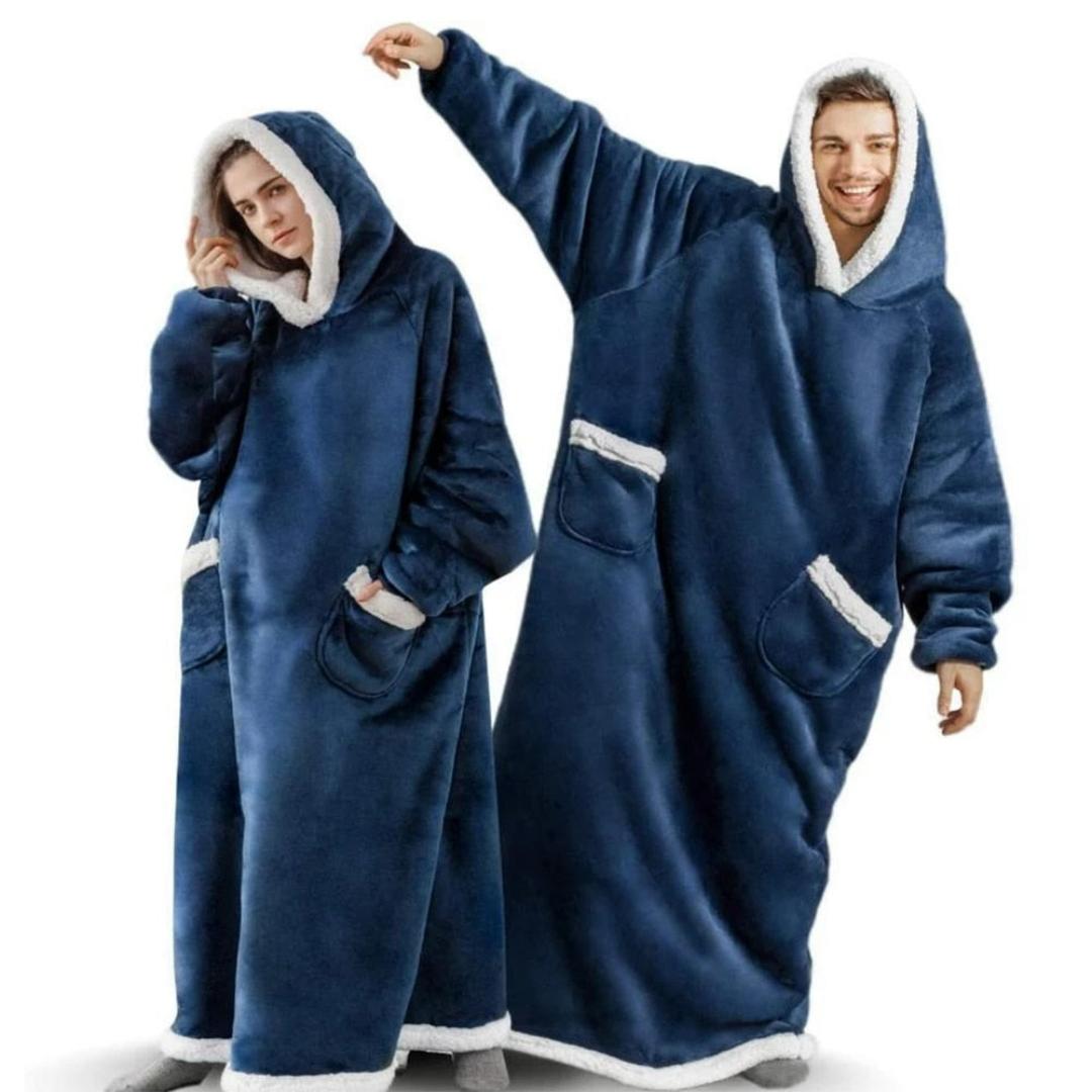 Person nyter en varm drikke i et mykt, overdimensjonert hetteteppe i fleece med ermer på en kjølig dag.