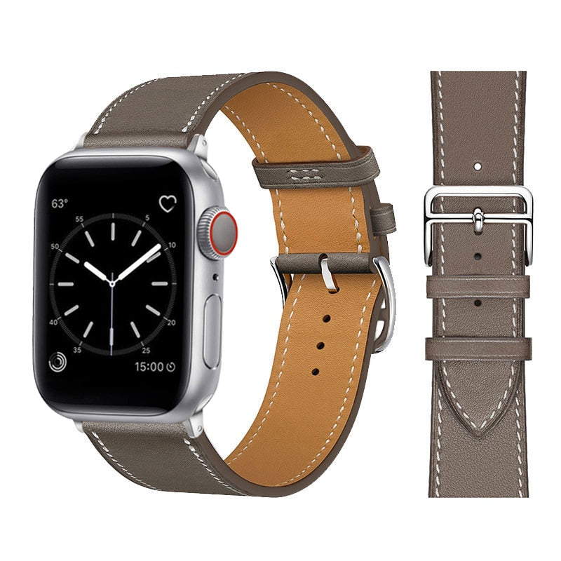Modell bruker Apple Watch med brunt kunstlærarmbånd, elegant og moderne