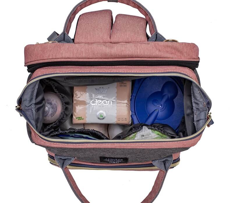 Romslig stelleveske for foreldre, brukt som babyseng på stranden, med baby som leker.