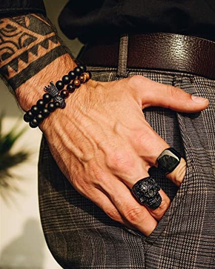 Nærbilde av matt onyks steinarmbånd med glinsende krone- og hodeskalleperler. Unisex krystallarmbånd.