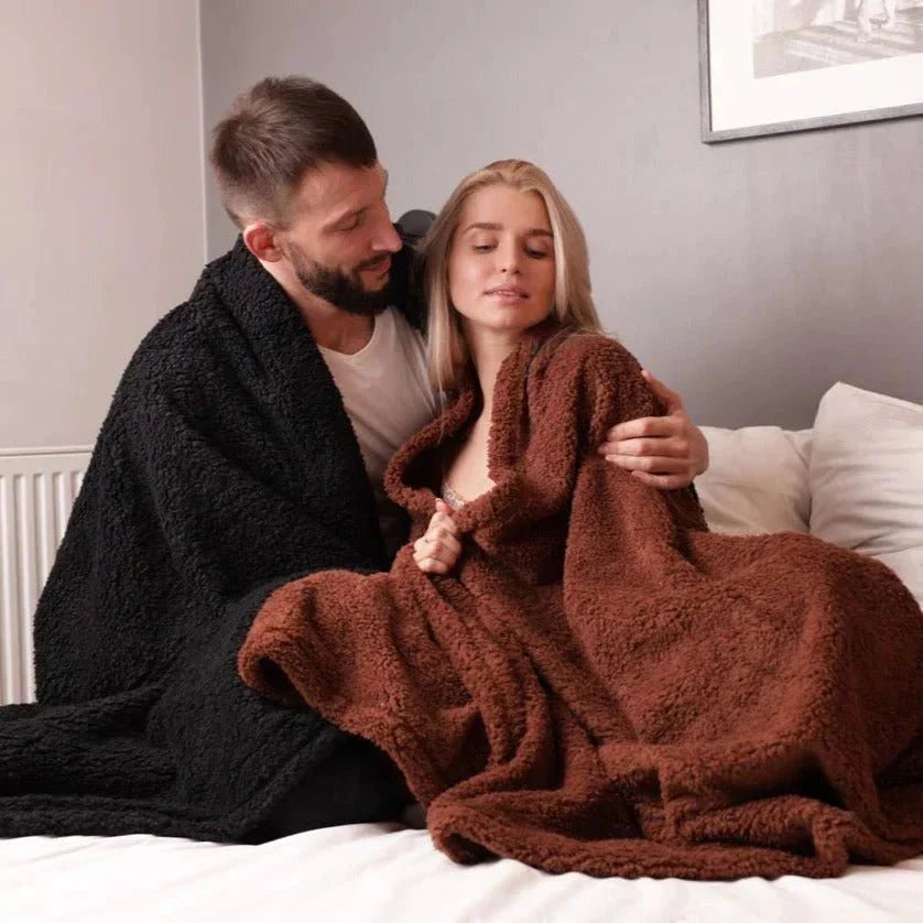 Dyrevennlig vanntett teppe på en sofa, beskytter møbler mot dyrehår og uhell. Mykt og slitesterkt.