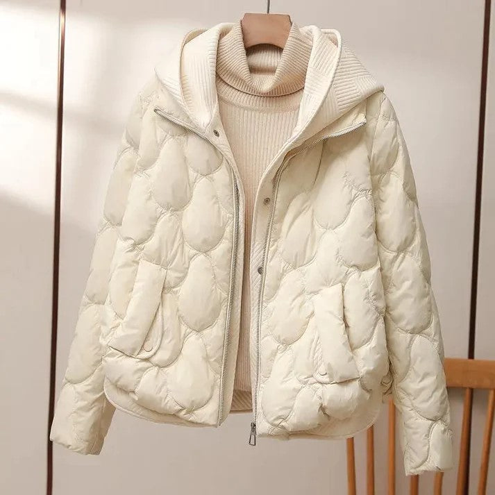 Beige dame vinterjakke med høy krage og kviltet design, en komfortabel og varm ytterjakke for kalde dager.
